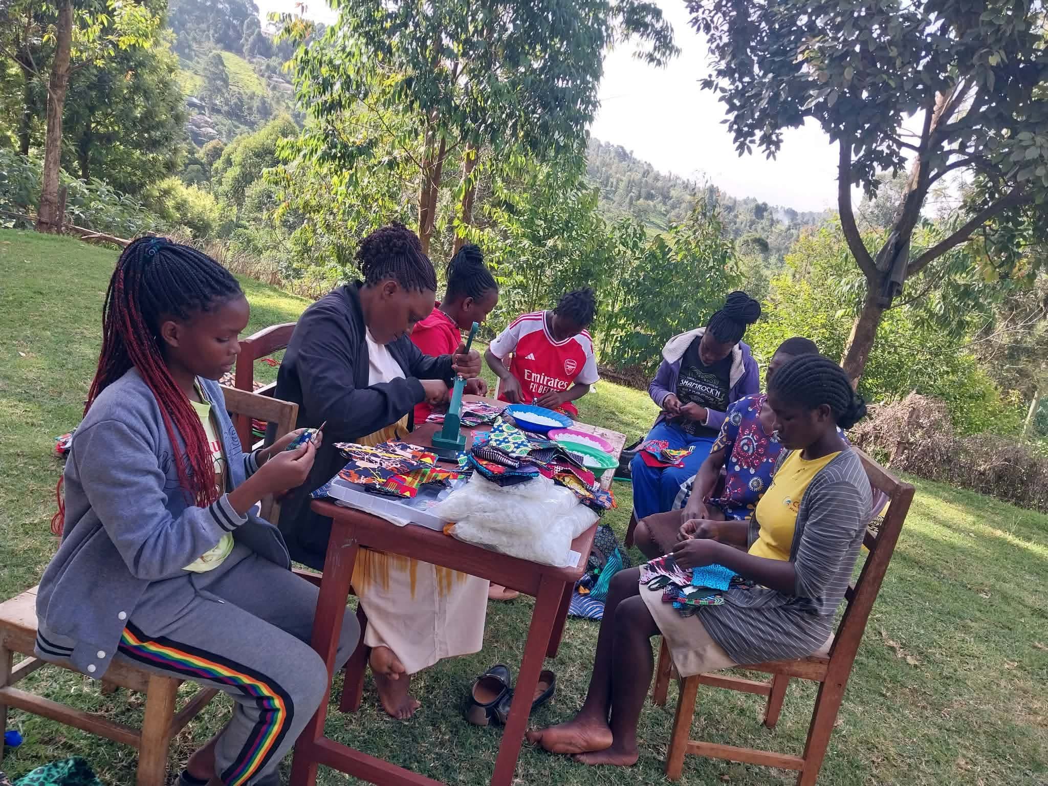 Young women assembling reusable hygiene products outdoors