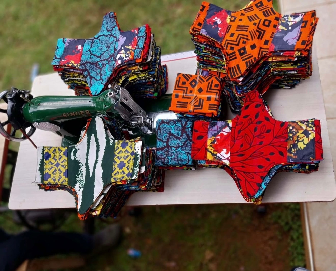 Colorful DignityKit pieces arranged beside a sewing machine