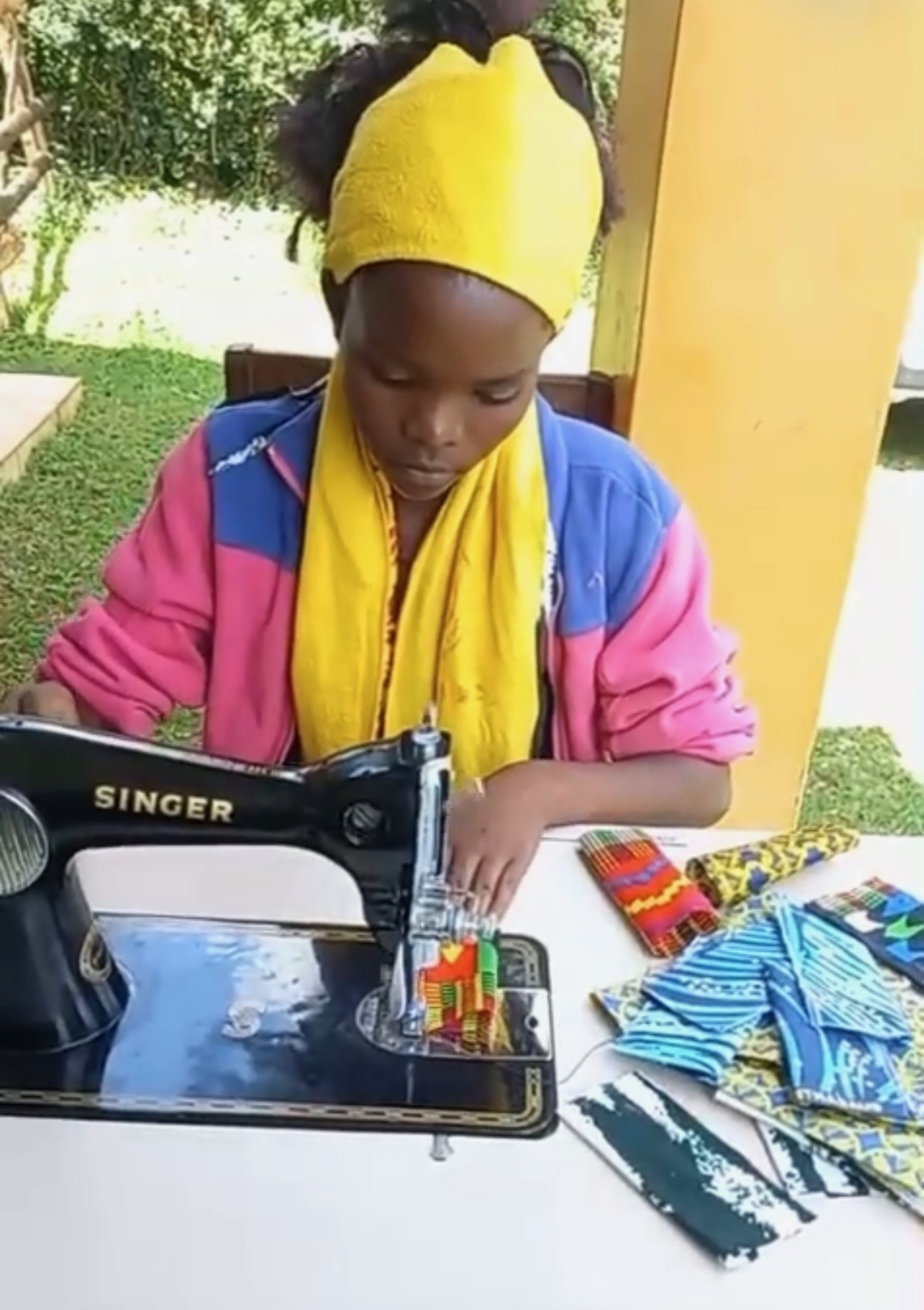 A girl sewing colorful fabric at the Dignity Sewing Center