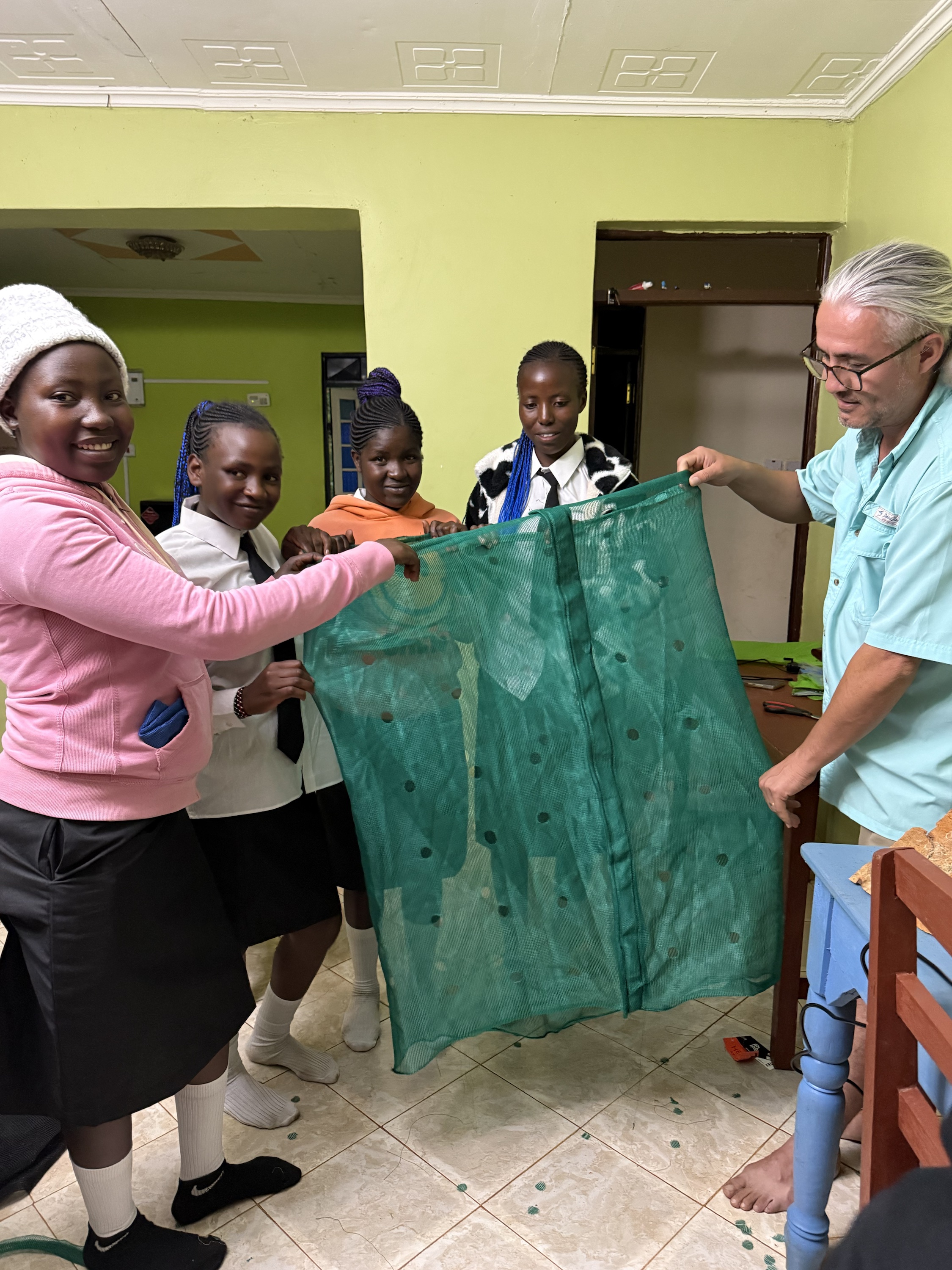 Girls and a Life Together Alliance supporter displaying newly prepared garden tower material