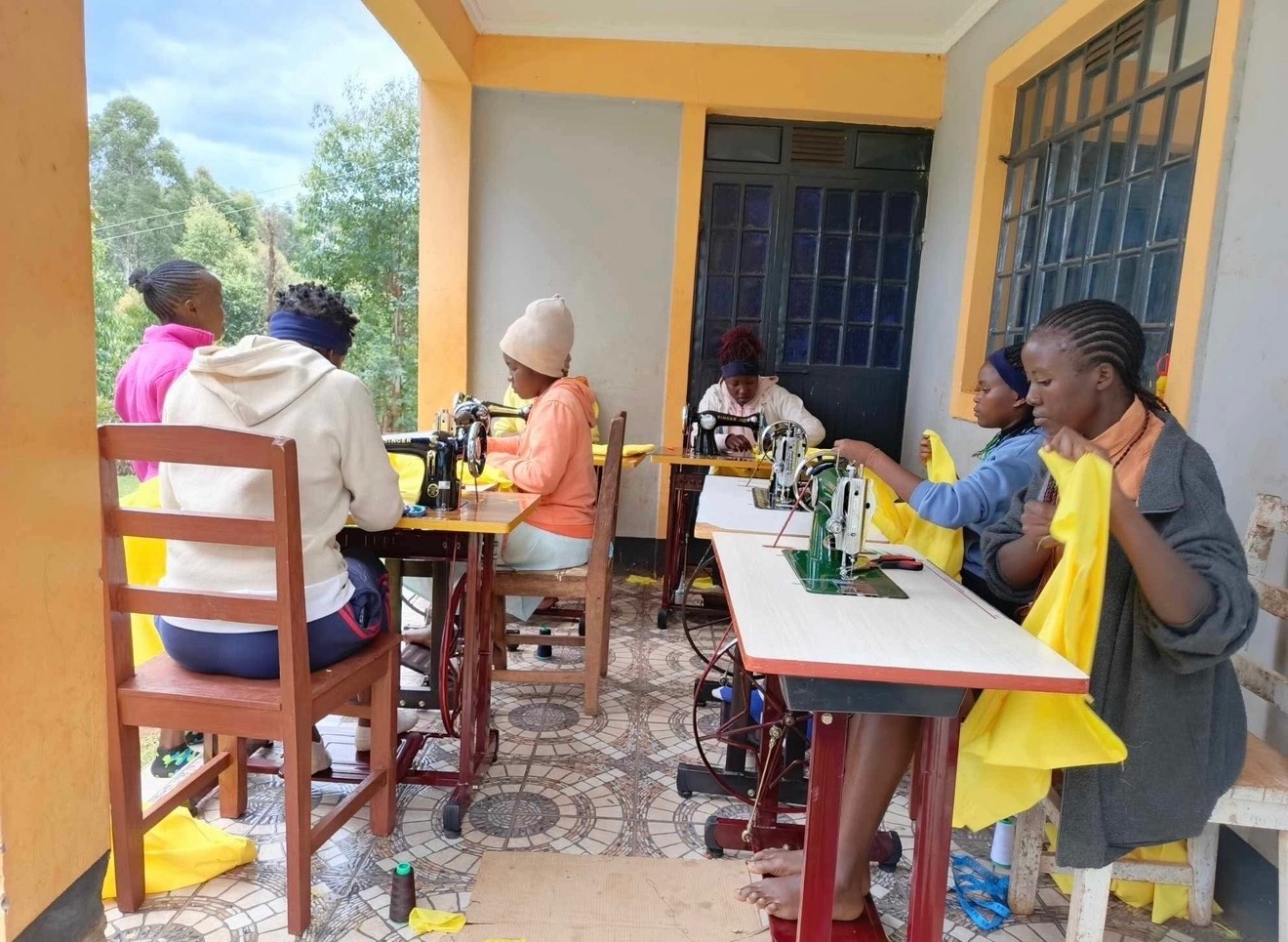 Girls working together at sewing machines in the Dignity Sewing Center