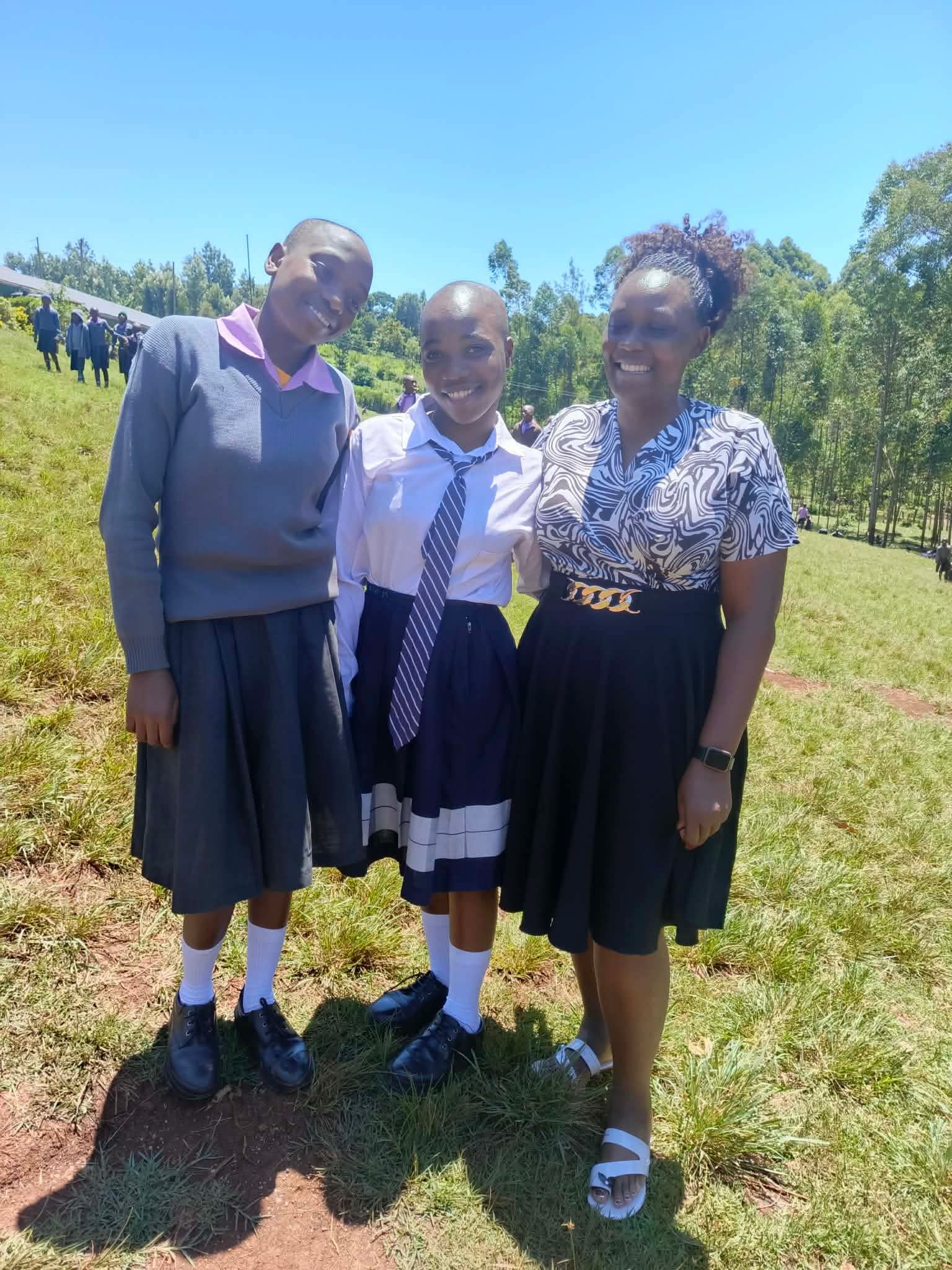 Two students standing with a Life Together Alliance team member